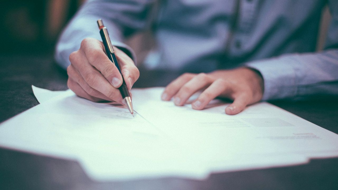 Fountain pen resting on signed contract papers